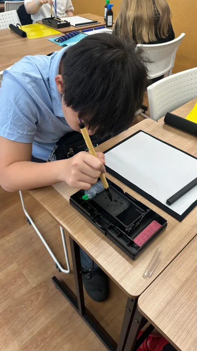 A student practicing Japanese calligraphy