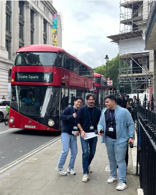 Students exploring London beside a red double-decker bus